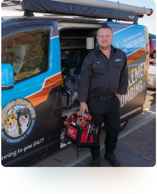 A plumber in a dark uniform stands beside an open van, holding a tool bag filled with various tools. The van is branded with plumbing advertisements and images of dogs.